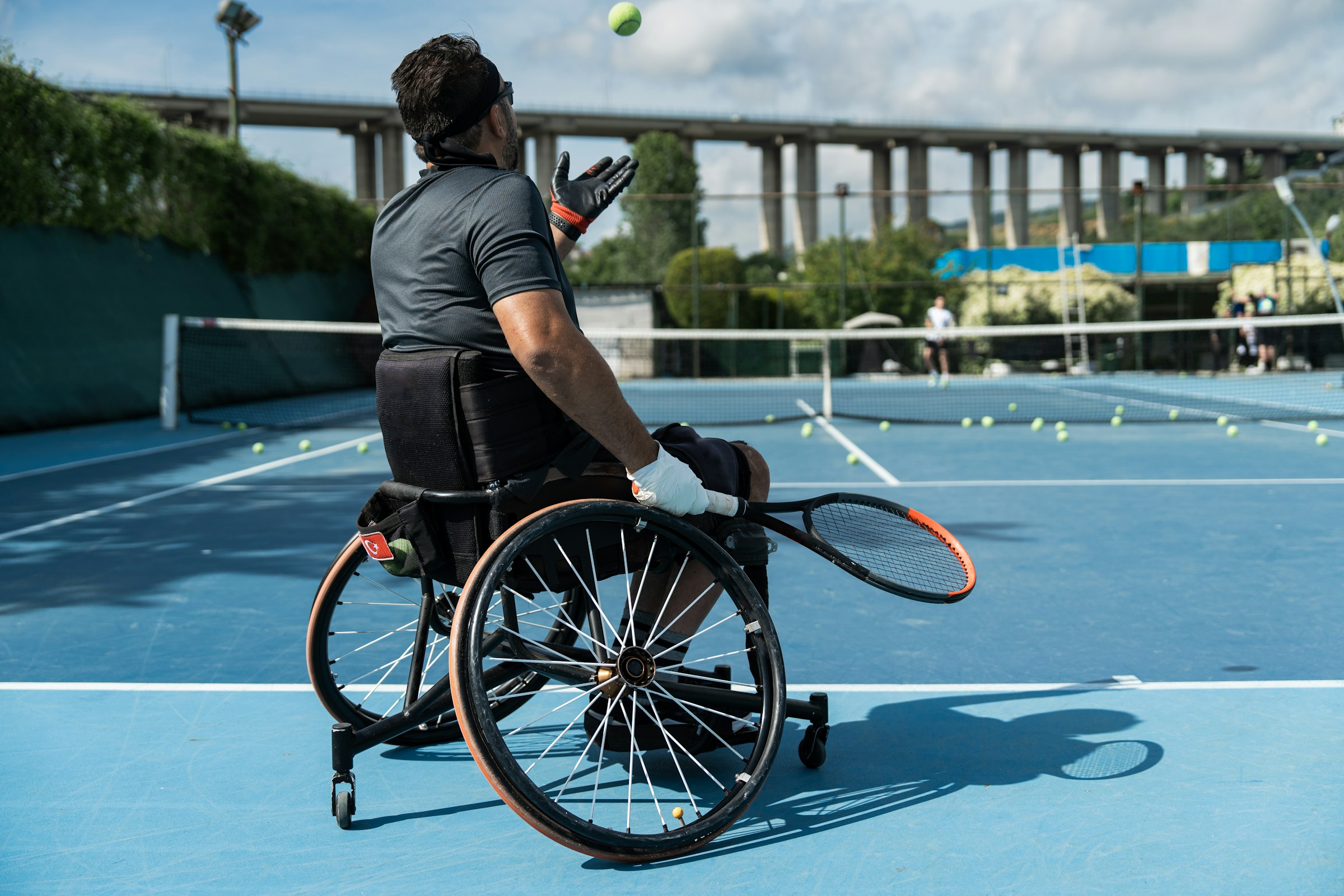 a man in a wheelchair playing tennis