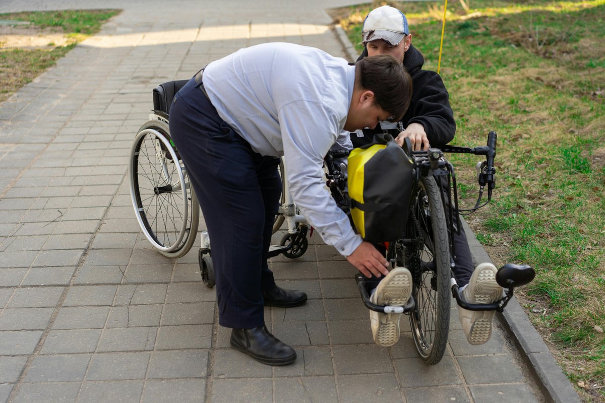 Person receiving assistive technology support with electric wheelchair outdoors