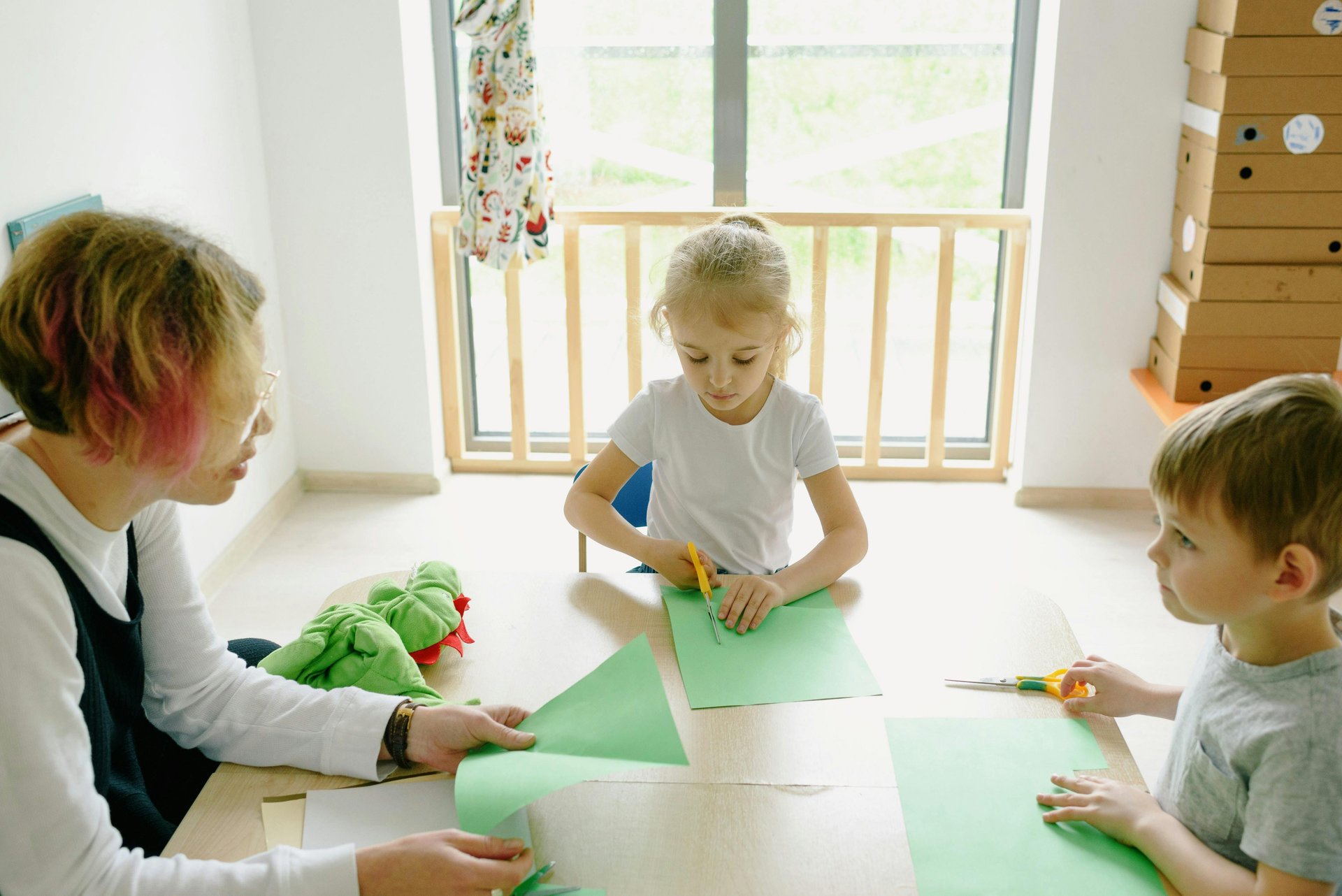 Children practising fine motor skills through paper cutting activities with an occupational therapist
