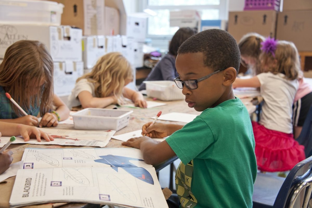 Child writing and developing literacy skills during a classroom assessment