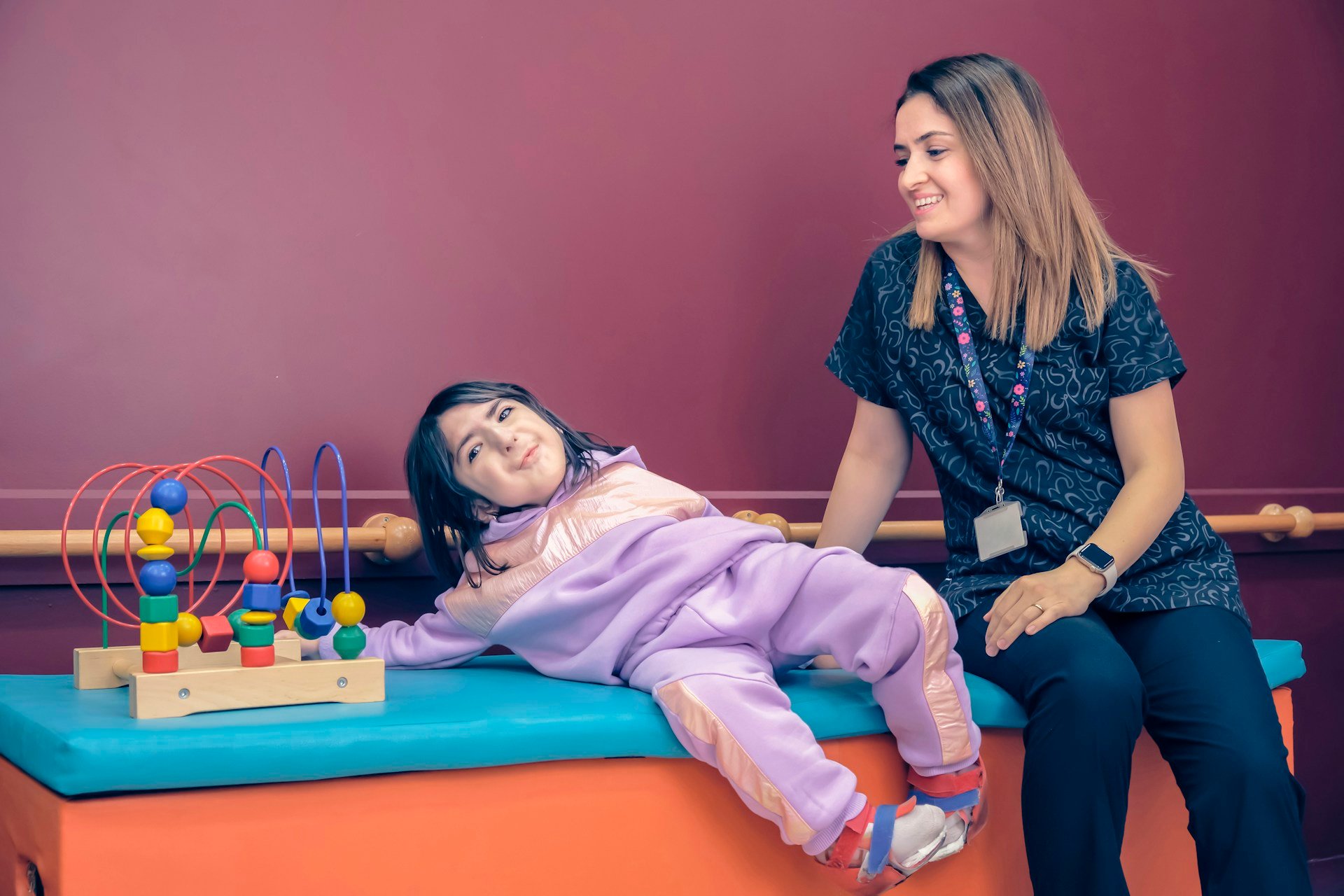 Speech pathologist supporting a child during a down syndrome speech therapy session