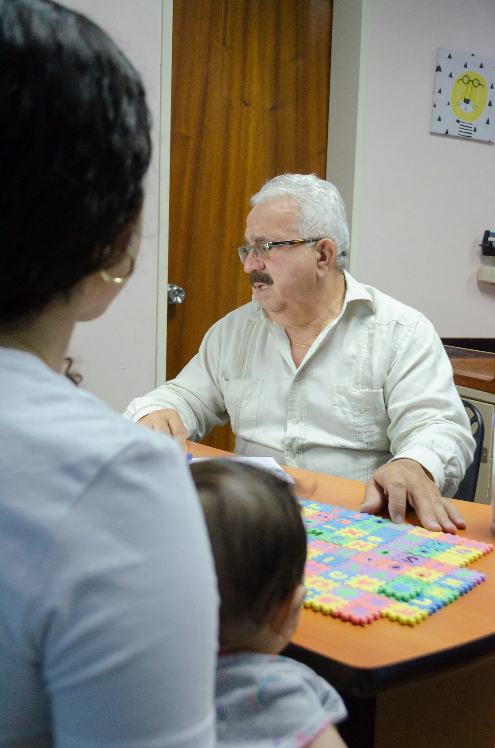 Child and parent meeting a speech pathologist for a down syndrome speech therapy assessment