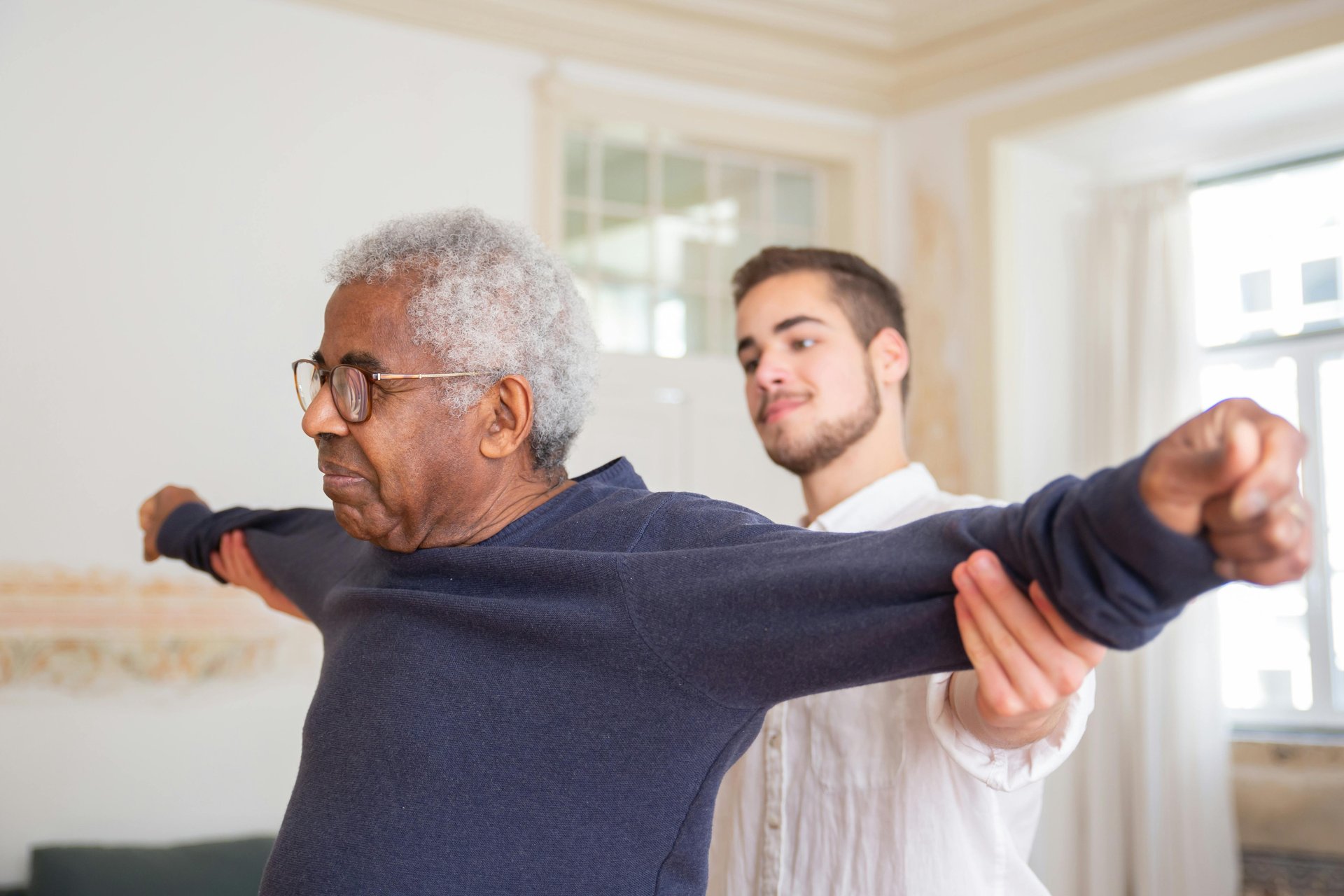 Senior receiving guided exercise from occupational therapist for falls prevention at home
