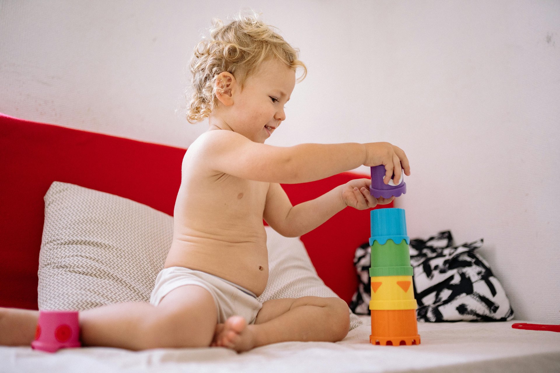 Toddler building a tower with colourful stacking toys during a developmental therapy activity