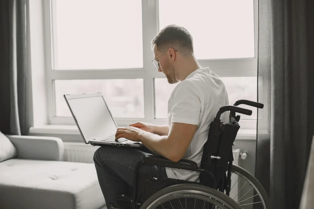 NDIS participant using laptop independently at home, representing individualised living options and independent living assessment