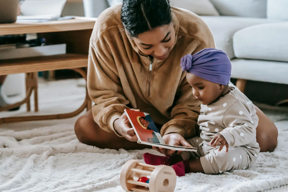 Mother and baby bonding over a book, supporting early language development