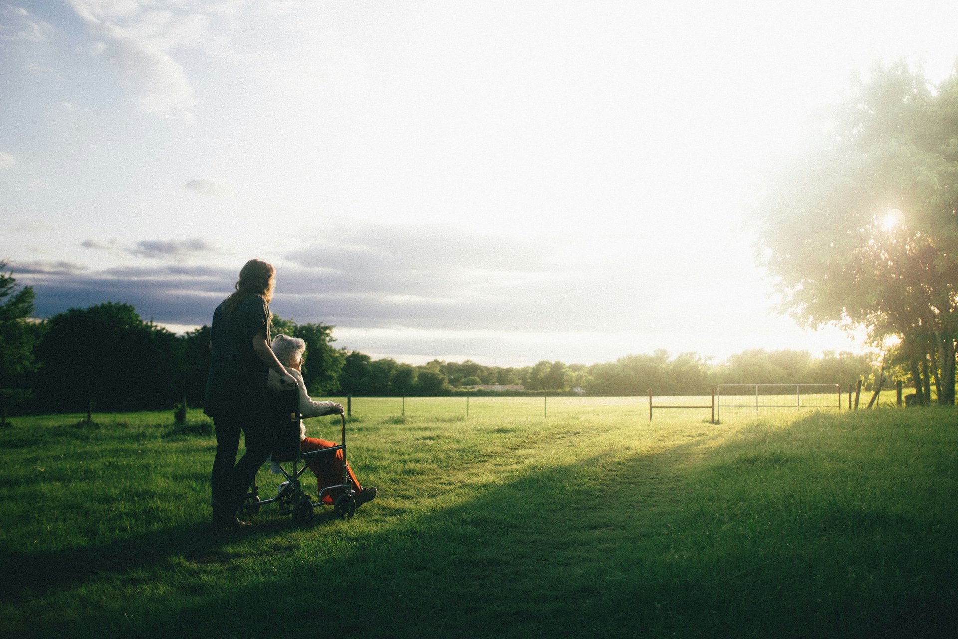 Support worker helping an older NDIS participant outdoors, showing mobile allied health support for self-managed and plan-managed NDIS clients