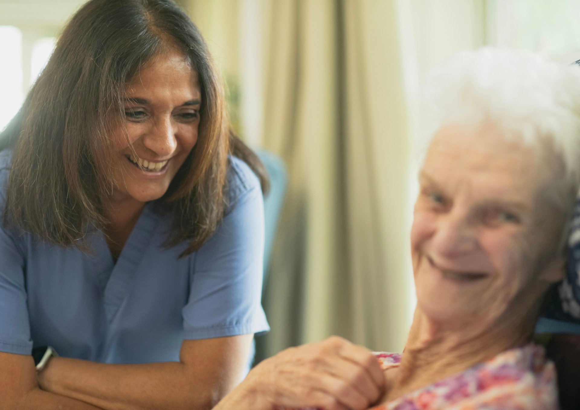 Occupational therapist smiling with an older client during an in-home NDIS therapy visit