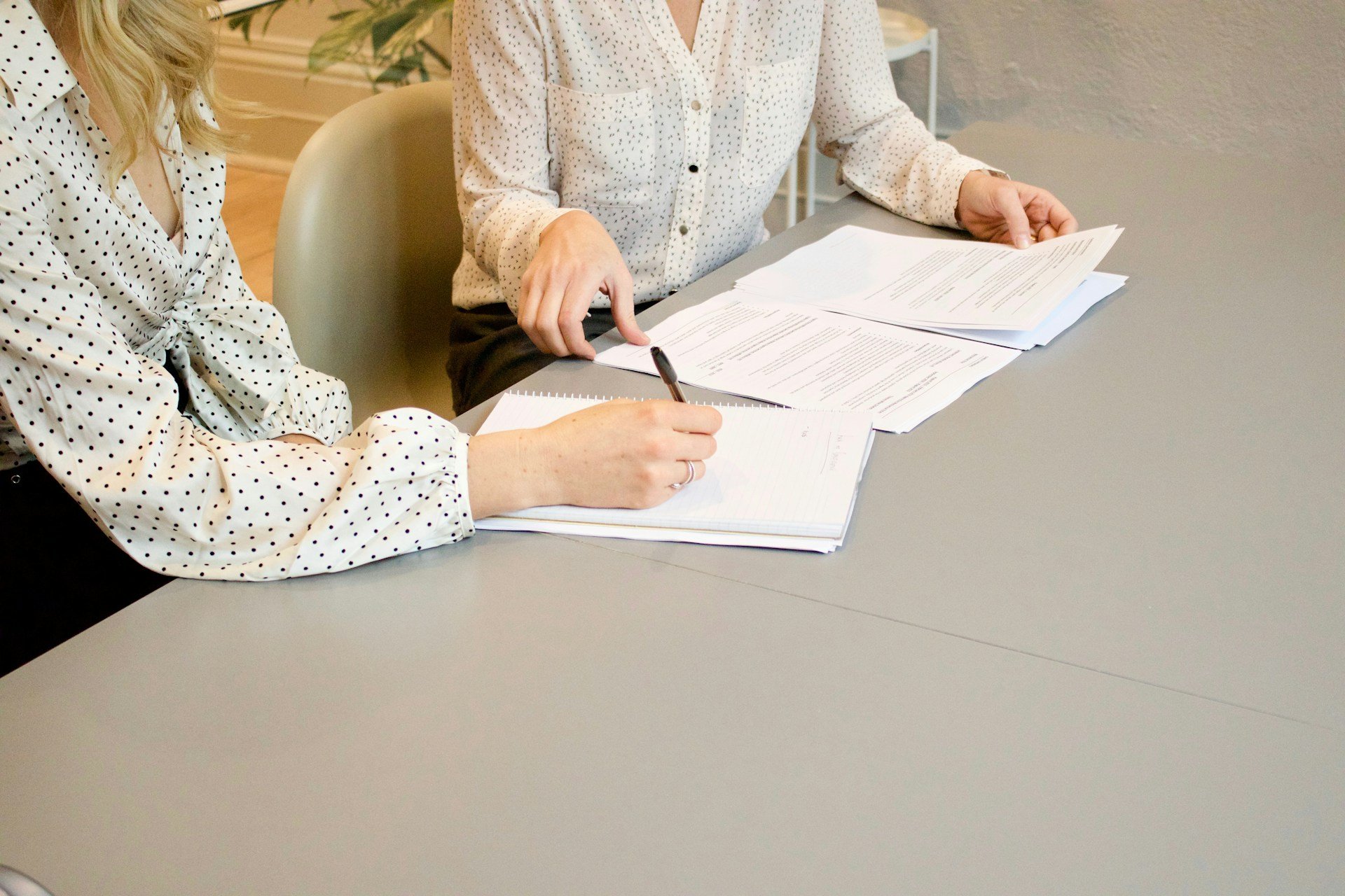 Two people reviewing documents and reports to prepare evidence for an NDIS plan review