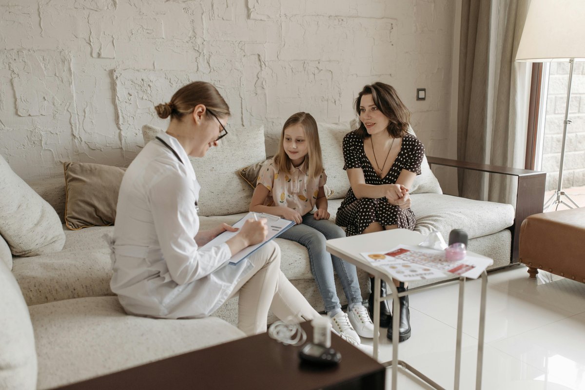 Healthcare professional consulting with a mother and daughter during a mobile NDIS speech pathology home visit