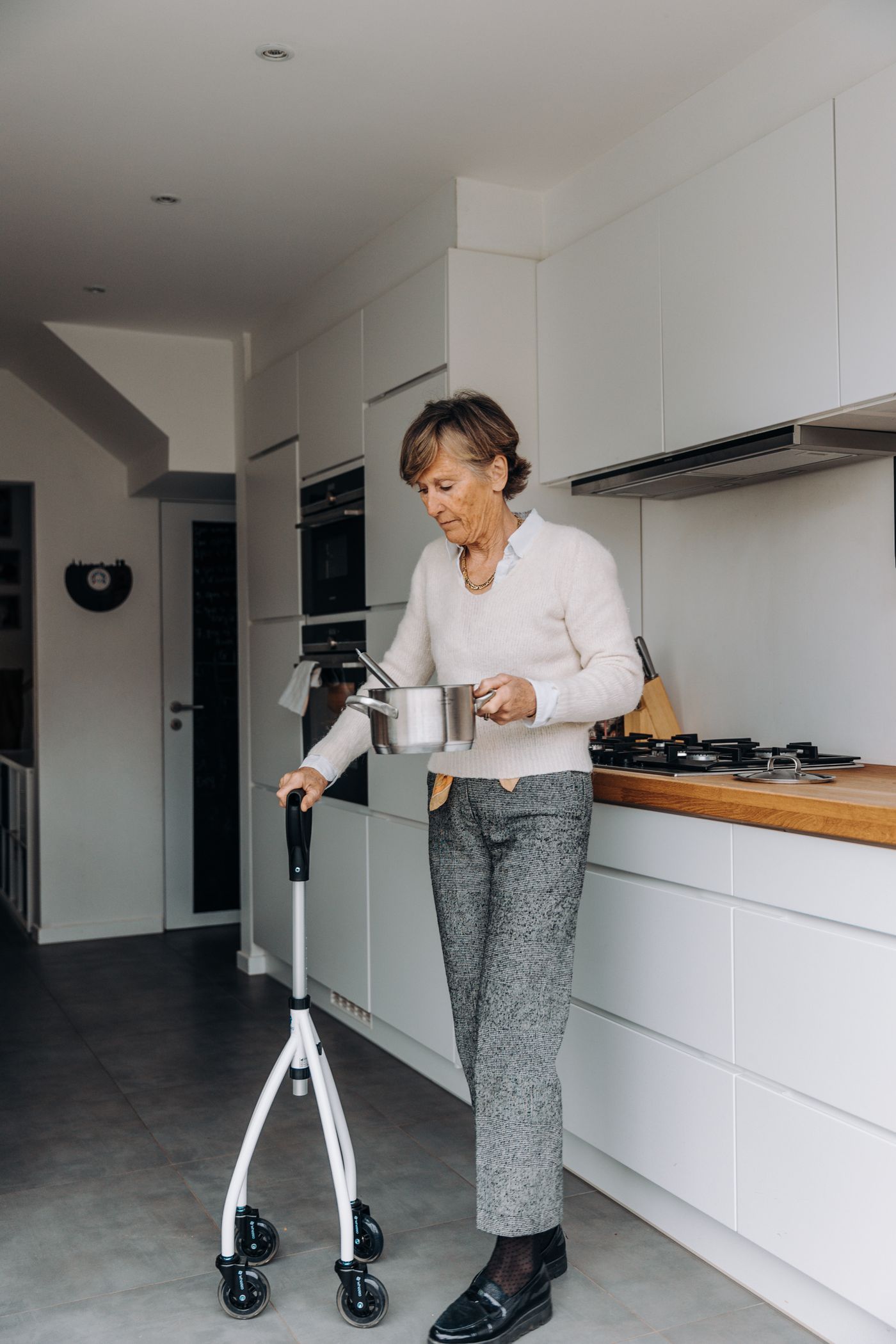 Older woman using a walking frame to move safely around her kitchen, the kind of home safety an occupational therapist in Ballina assesses