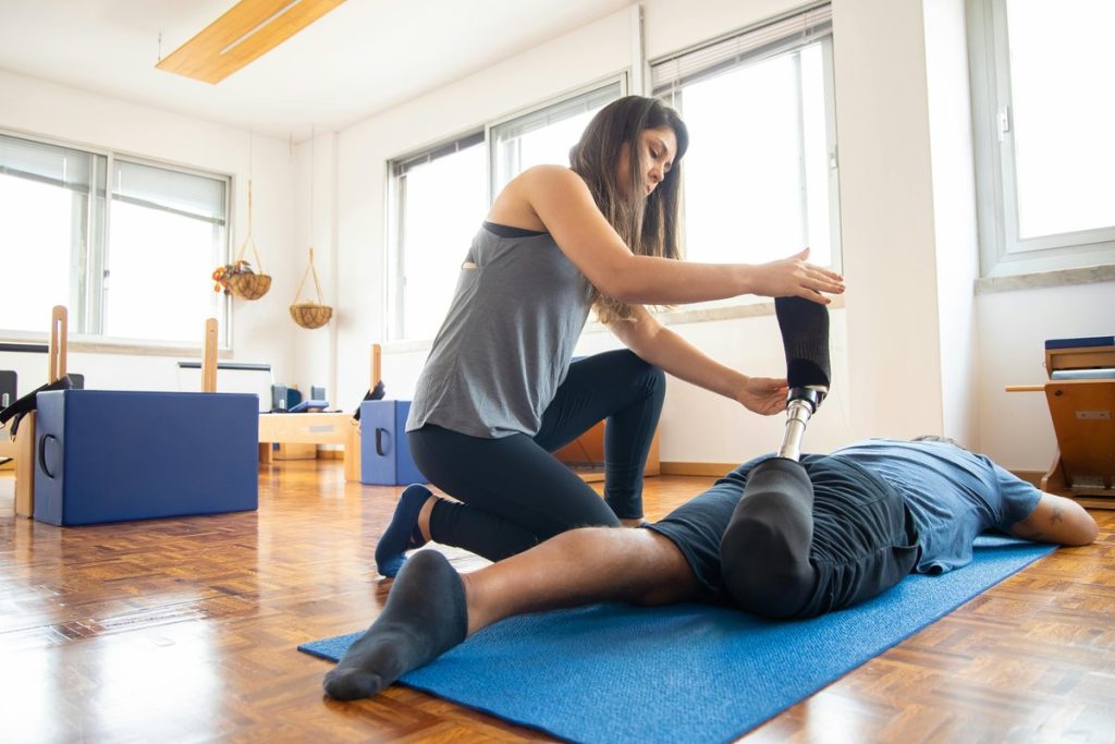 Therapist helping patient during rehabilitation session with assistive equipment