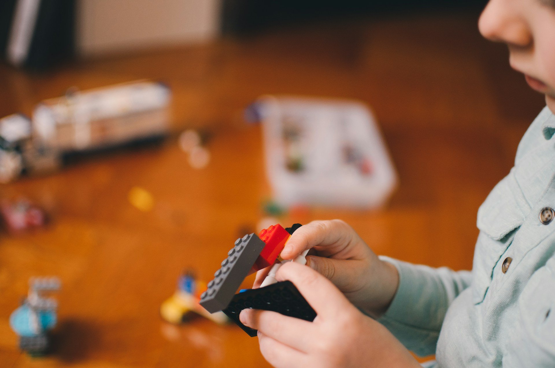 Child building with blocks during a play based occupational therapy Brisbane session at home to develop fine motor skills.