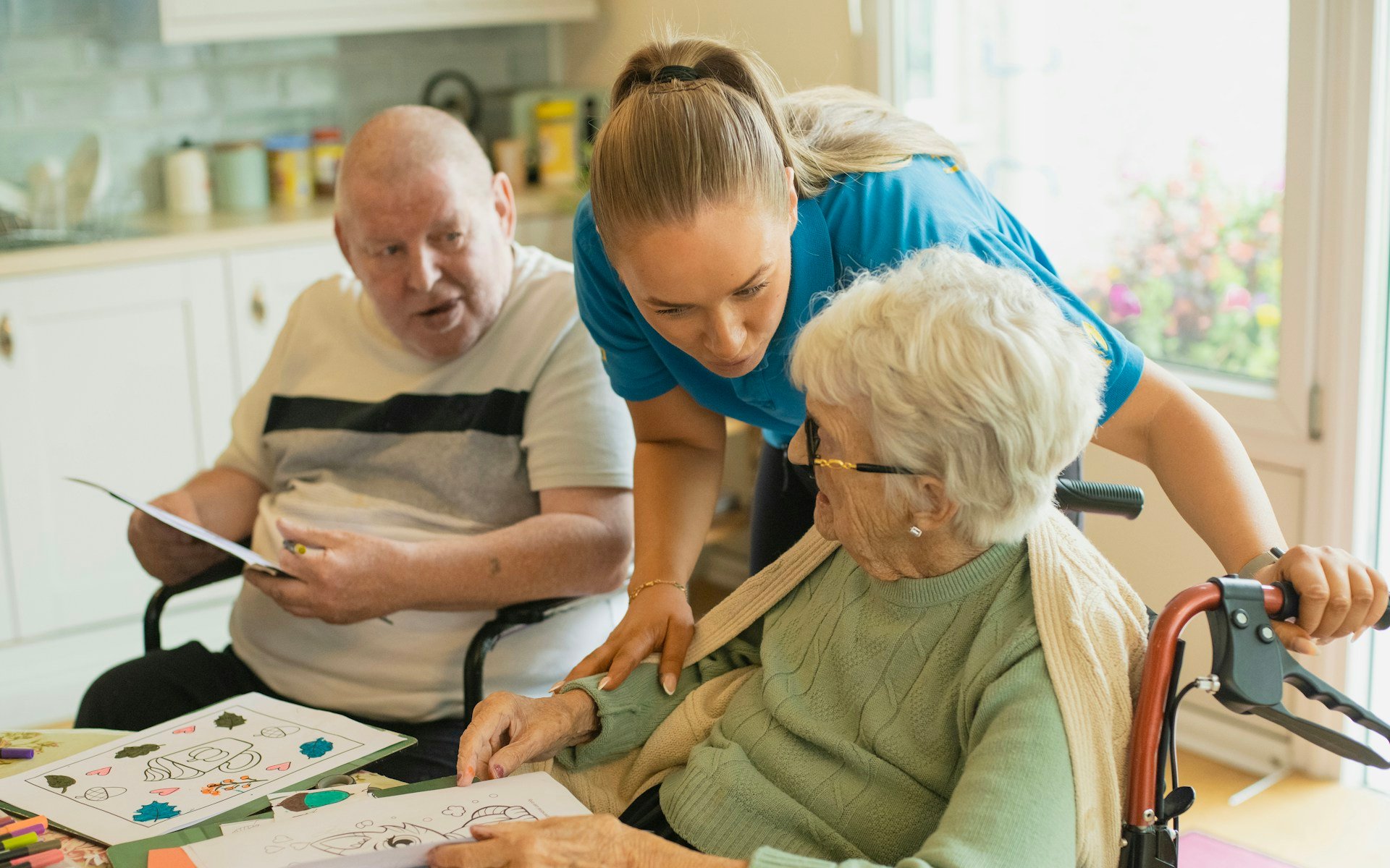 Occupational therapy Gold Coast home visit, an occupational therapist helping an older woman with a daily living activity at her kitchen table