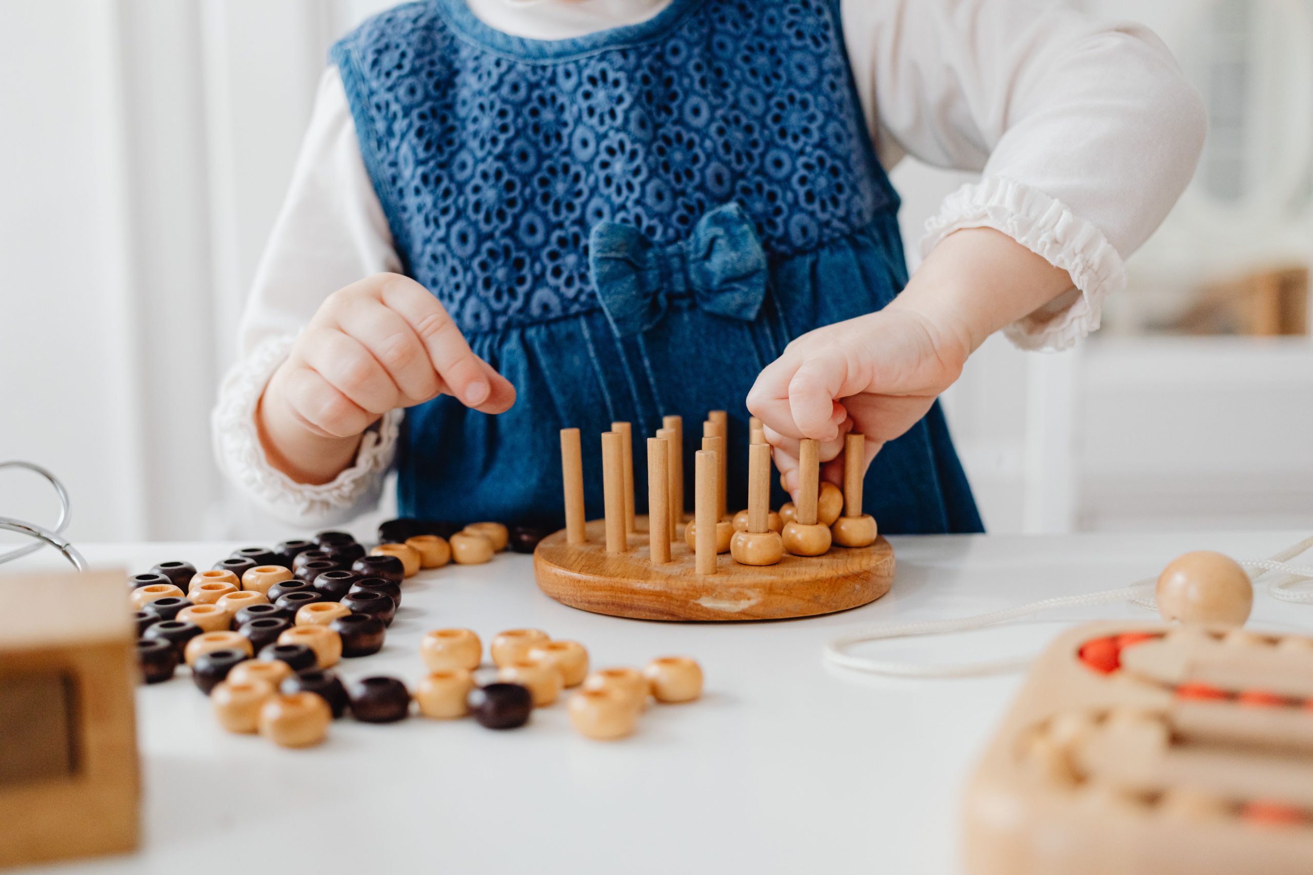 Young child practising fine motor skills with a wooden sorting toy at home, a common activity in occupational therapy in Lismore