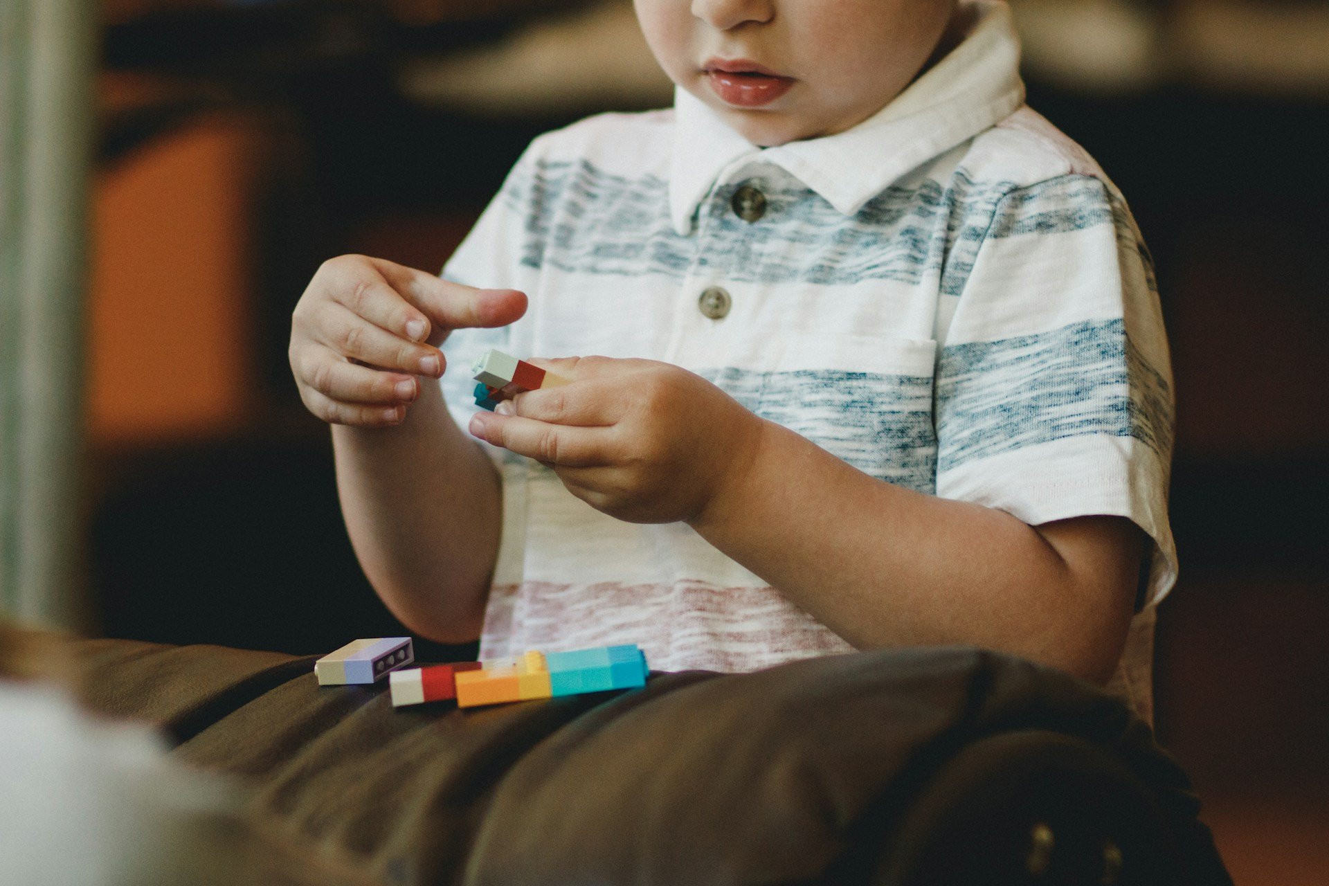 Young child exploring colourful building blocks during a sensory profile assessment
